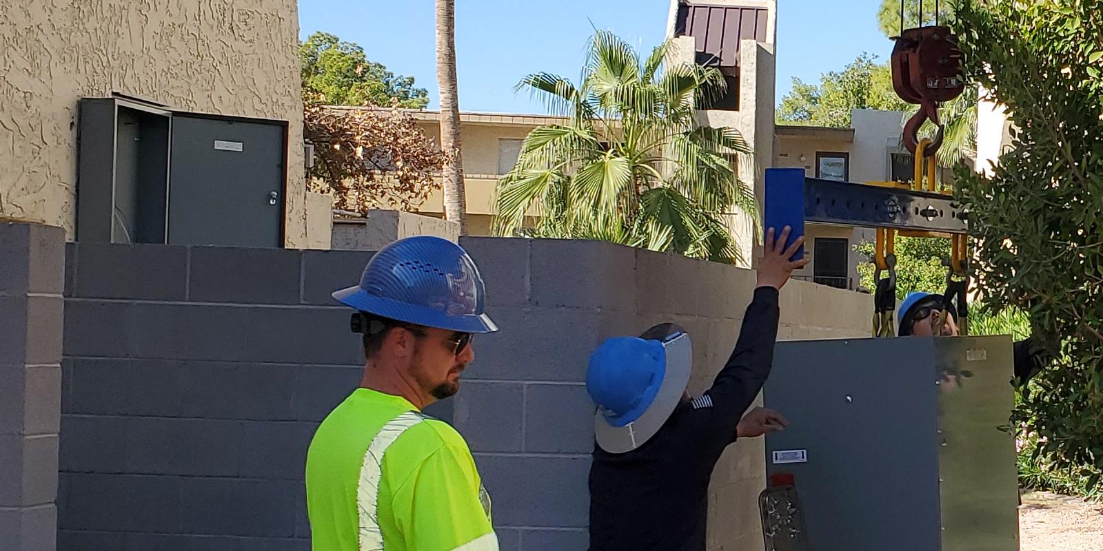 Crane setting new electrical equipment at a multifamily property in Phoenix